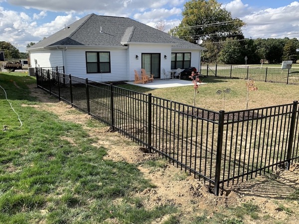 A black ornamental fence around a white Fort Wayne home