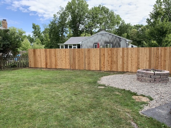 A wood privacy fence beside a back-yard fire pit