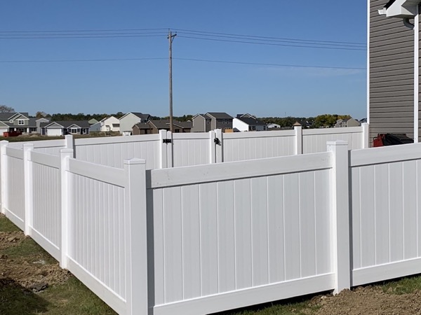 A white vinyl privacy fence enclosing a yard