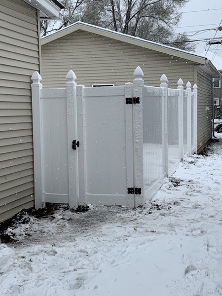 A white vinyl fence and gate at a Fort Wayne home