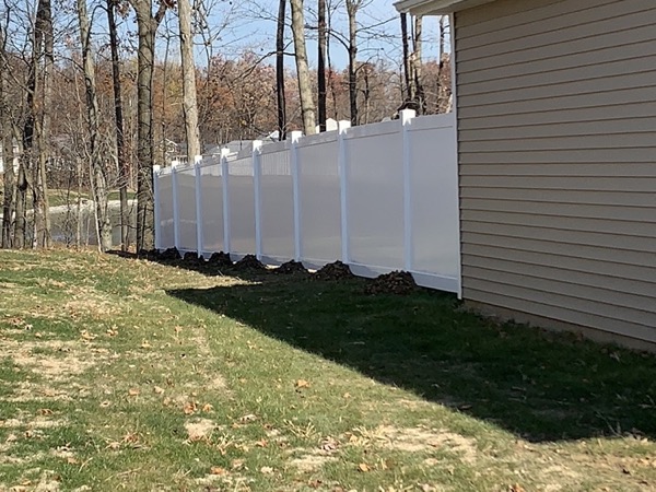 A white vinyl privacy fence enclosing a back yard