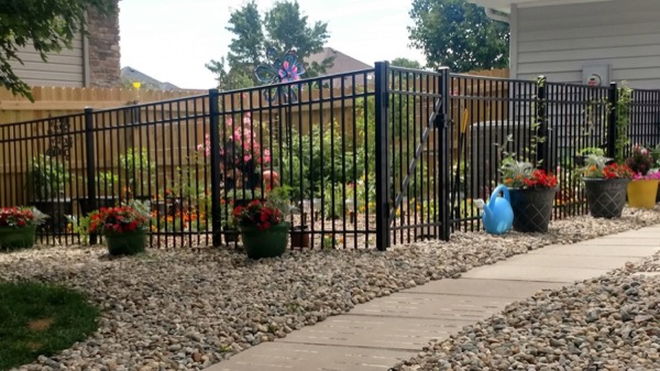 A black ornamental aluminum fence and gate around a Fort Wayne garden