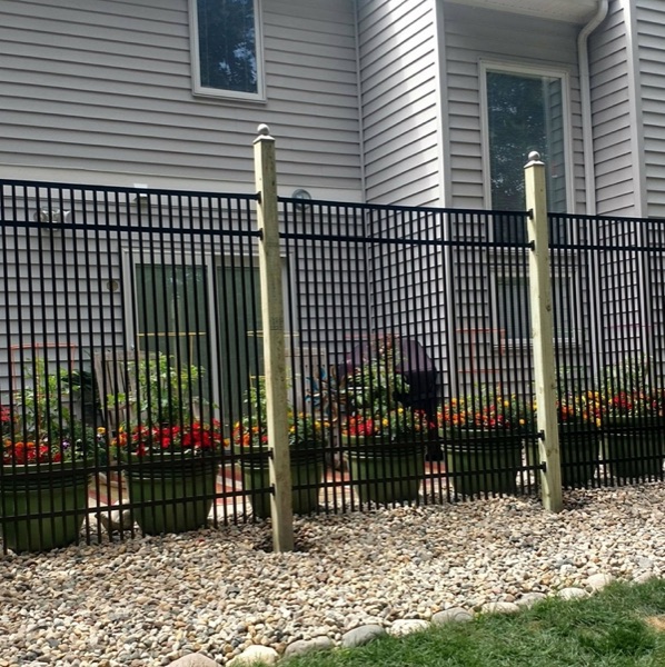 A black aluminum fence installed along the side of a Fort Wayne home